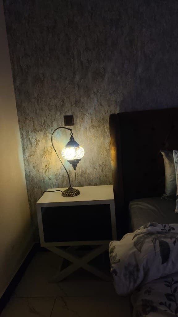 Cozy bedroom with Turkish mosaic lamp and tufted headboard at OliveHill