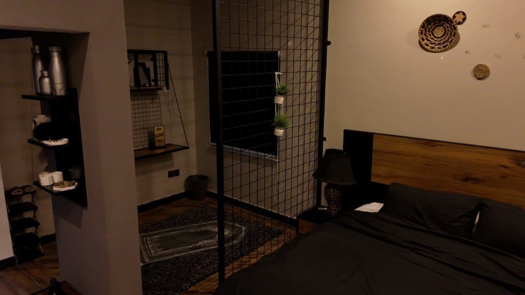 Modern bedroom with wood headboard and mesh room divider at OliveHill