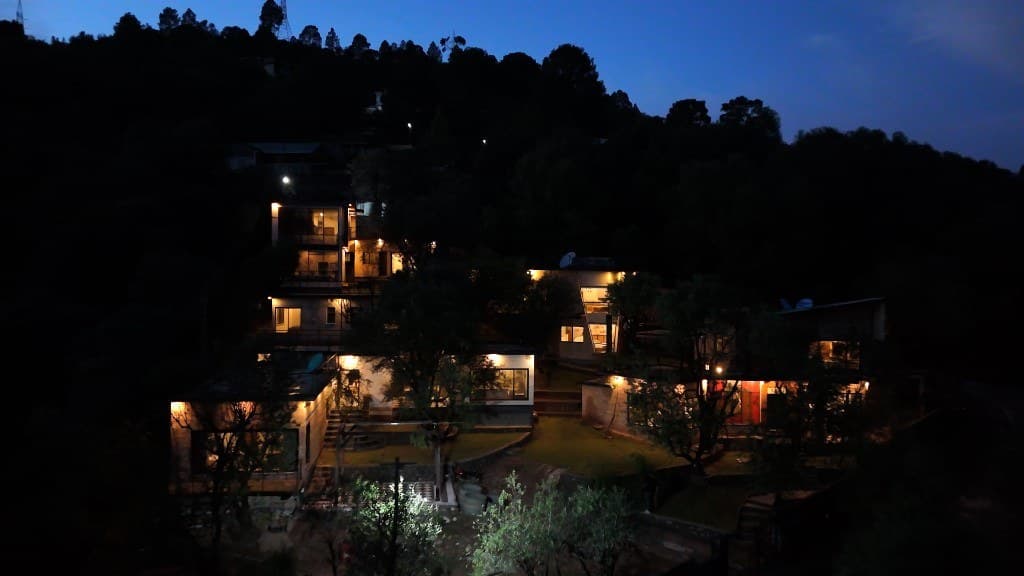 OliveHill Cottages compound glowing at twilight on a forested Murree hillside