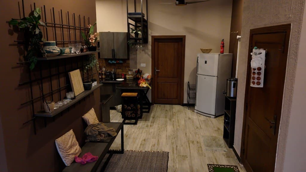 Cozy entryway and kitchen with industrial shelving at OliveHill